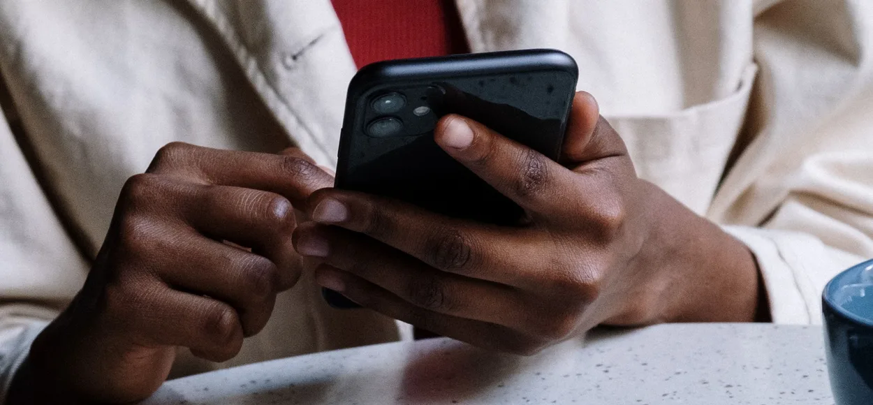 Hands holding a smartphone above a table