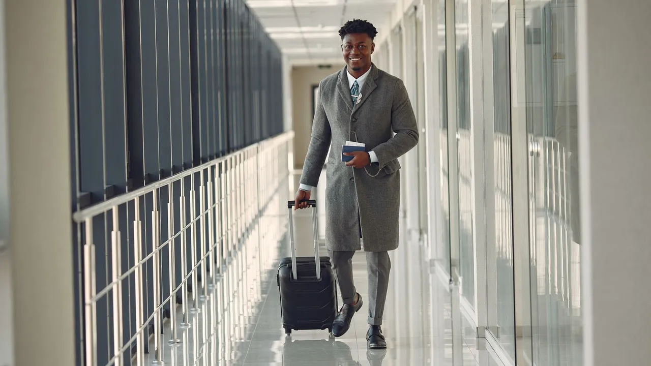 Traveller with a suitcase and passport in an airport corridor